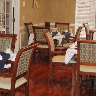 A cozy dining room with set tables and chairs.