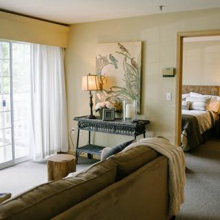 A cozy living room with a view into the bedroom, featuring stylish decor and ample natural light.