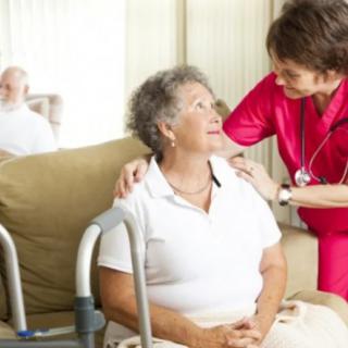 A nurse providing care and support to a senior woman using a walker.