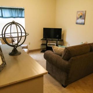 A cozy living room with a sofa and television setup.