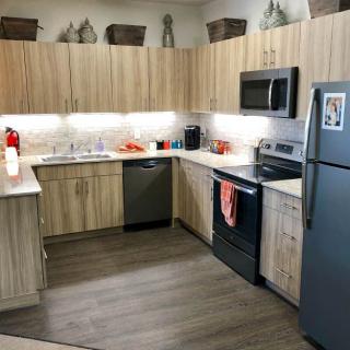 A modern kitchen with wood cabinets and stainless steel appliances.
