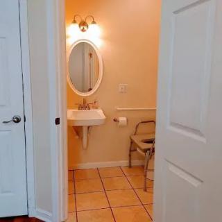 A view of a bathroom featuring a sink, mirror, and tiled floor.