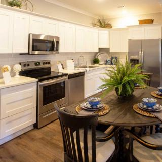 A modern kitchen with stainless steel appliances and a stylish dining area.