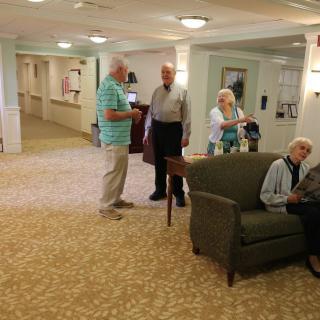 A group of elderly people socializing in a community seating area.