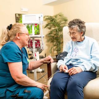 A nurse interacts with a senior patient in a healthcare setting.