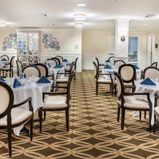 A well-furnished dining room with neatly arranged tables and chairs, featuring elegant decor.