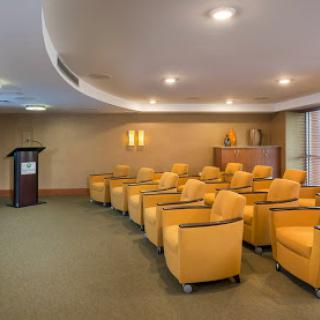 A well-designed conference room featuring bright yellow seating and a podium, ready for presentations or meetings.