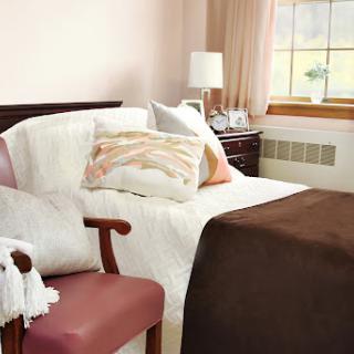 A cozy and inviting bedroom featuring a neatly made bed, decorative pillows, and soft lighting.
