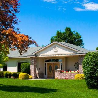 A charming suburban house with a well-maintained lawn and lush greenery on a sunny day.