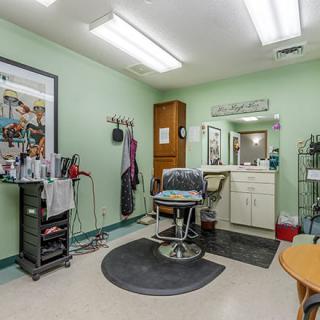 A well-equipped hair salon with a barber chair and a mirror.