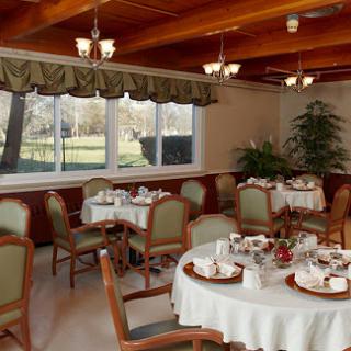 A cozy dining room setup with elegant tables and a pleasant outdoor view.