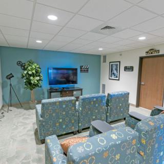 A cozy waiting room with comfortable seating and a television for entertainment.