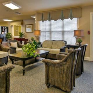 A cozy and well-lit living room with comfortable seating and indoor plants.