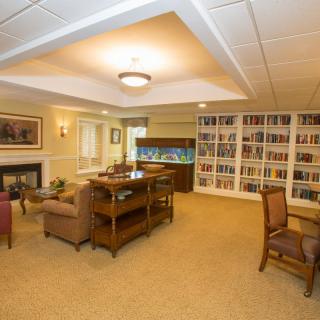 A cozy library with comfortable seating and shelves filled with books.