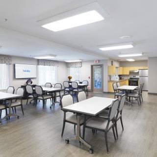 A spacious dining and kitchen area with modern furnishings and large windows.