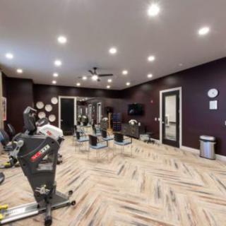 A modern indoor gym with exercise equipment and stationary bikes.