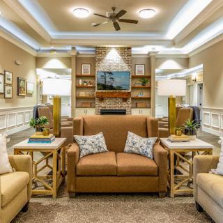 A cozy and elegantly designed living room featuring comfortable sofas, stylish lamps, and a built-in bookshelf.