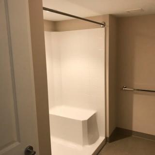 Accessible bathroom with a shower and grab bar.