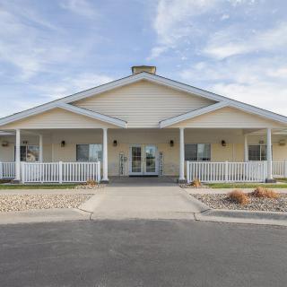 A single-story residential building with a porch and front yard.