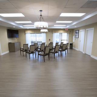 A conference room set up with chairs arranged in a circle, featuring wood flooring and modern lighting.