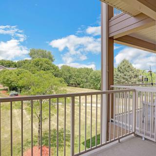 A balcony overlooking a scenic view with trees and a clear blue sky.