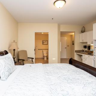 A cozy bedroom with a kitchenette and comfortable furnishings.
