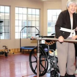 An elderly person undergoing physical therapy using a walker in a rehabilitation facility.