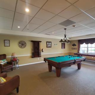 A cozy indoor game room featuring a pool table and seating area.