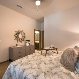 A modern bedroom featuring elegant decor with a stylish bedding arrangement and contemporary furniture.