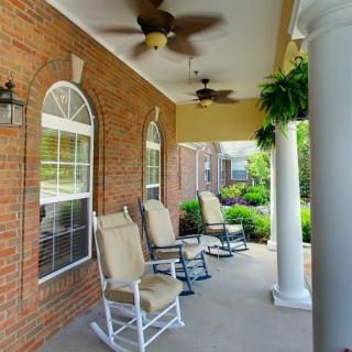 A cozy porch with rocking chairs and ceiling fans, perfect for relaxation.