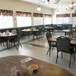 An empty dining room in a restaurant with neatly arranged tables and chairs.