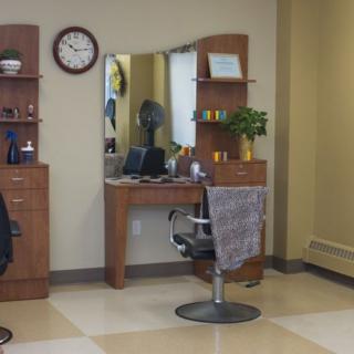 A modern salon workspace with a styling chair and mirror.
