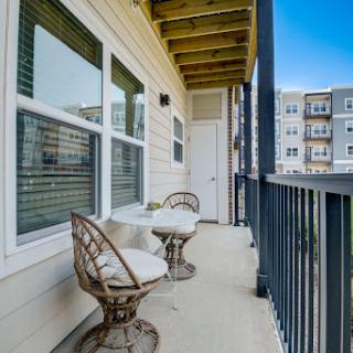 A cozy balcony featuring two chairs, perfect for enjoying a cup of coffee in the morning.