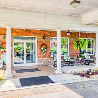 A welcoming porch with rocking chairs and floral decorations at the entrance of a building.