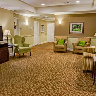 A cozy lobby featuring comfortable seating, a patterned carpet, and warm lighting.
