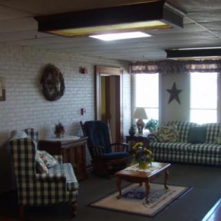 A cozy living room with country-style decor featuring checkered furniture, a coffee table, and decorative accents.