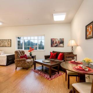 A cozy living room with elegant decor, featuring a comfortable sofa, armchair, and dining table.