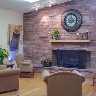 A cozy living room with a brick wall fireplace, comfortable seating, and decorative elements.