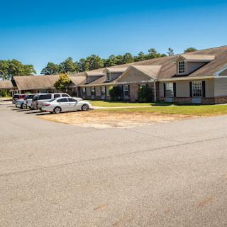 A view of a suburban residential area featuring single-story homes and a parking lot.