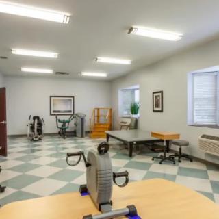 A spacious rehabilitation room equipped with therapy and exercise equipment.