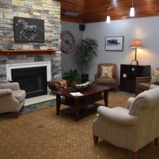 A cozy living room with a stone fireplace and comfortable seating.