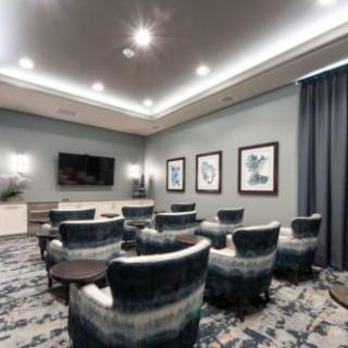A modern conference room with comfortable seating and a large television for presentations.