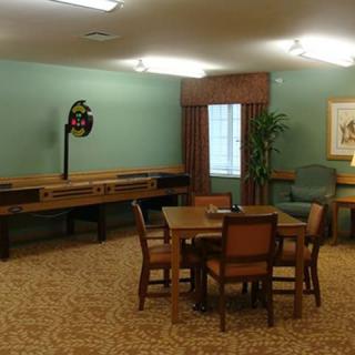 A cozy room with a table and chairs, featuring a shuffleboard game along the wall.