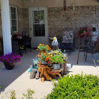 A cozy and vibrant porch filled with colorful flowers and a welcoming seating area.