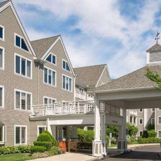 A residential building with a covered entrance and a clear blue sky.