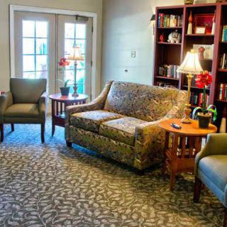 Cozy living room with a sofa, chairs, and a bookshelf.