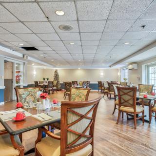 A spacious and well-lit dining area featuring elegantly arranged tables and chairs.