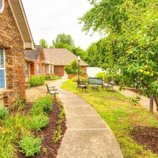 A scenic walkway surrounded by lush greenery and residential houses.