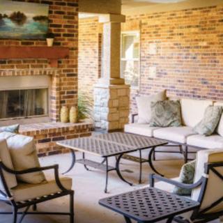 A cozy living room with brick walls and a fireplace, featuring comfortable seating and elegant decor.
