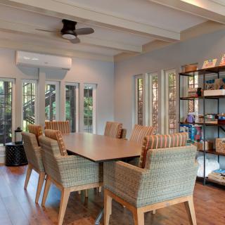 A modern dining area with rattan chairs and natural lighting.